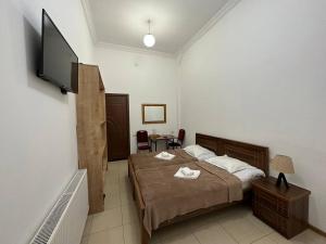 a bedroom with a bed and a flat screen tv at Hotel Tbilisi Guest Home in Tbilisi City