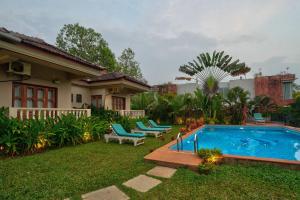 einen Hinterhof mit einem Pool und einem Haus in der Unterkunft Casa De Royale - Anjuna in Anjuna
