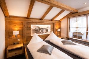 two beds in a room with wooden walls at Landhaus Bauer in Oberstdorf