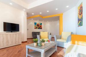 a living room with a couch and a tv at Sole e Girasoli in Molfetta