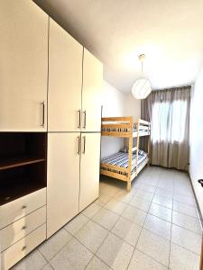 una cucina con armadietti bianchi e un letto a castello di Matteo's Apartments Cecina Mare a Cecina