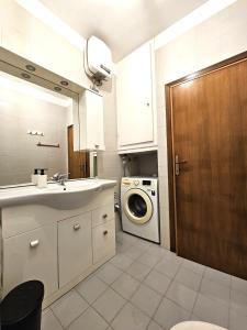 un bagno con lavandino e lavatrice di Matteo's Apartments Cecina Mare a Cecina