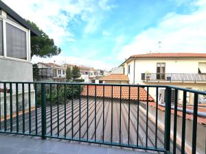 un balcone con una recinzione verde e alcuni edifici di Matteo's Apartments Cecina Mare a Cecina