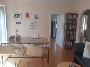 een woonkamer met een houten tafel en stoelen bij Central and cosy apartment tramstrasse 8050 Zürich in Zürich