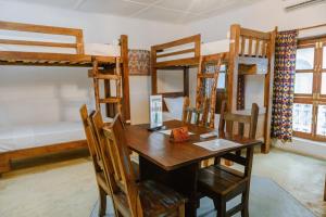 jadalnia ze stołem, krzesłami i łóżkami piętrowymi w obiekcie Shoki Shoki Hostel w mieście Zanzibar