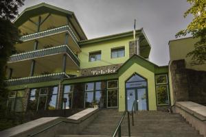 a yellow and green building with stairs in front at Hostel Teleki in Sovata