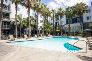 an outdoor swimming pool with palm trees and buildings at Playa Vista 1br w pool wd gym nr beach LAX-930 in Los Angeles