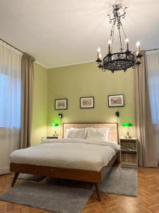 Un dormitorio con una cama grande y una lámpara de araña. en Kesletz House, en Sibiu