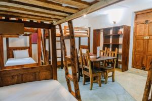 a room with bunk beds and a table and chairs at Shoki Shoki Hostel in Zanzibar City