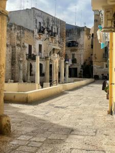 uma rua vazia num edifício antigo com colunas em La Stanza em Bari