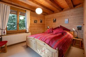 een slaapkamer met een bed in een houten hut bij L'Alouvy Winter Dream Chalet for Family at Verbier in Verbier
