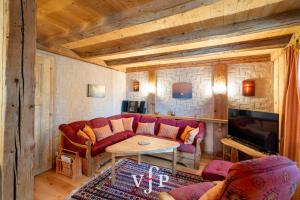 a living room with a red couch and a tv at L'Alouvy Winter Dream Chalet for Family at Verbier in Verbier