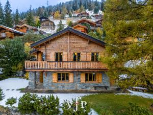 een boomhut met een terras op een met sneeuw bedekte tuin bij L'Alouvy Winter Dream Chalet for Family at Verbier in Verbier