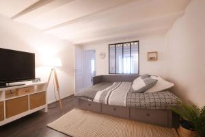 um quarto com uma cama e uma televisão de ecrã plano em Cabana & Cœur de Ville - Proche Gare & Lac em Annecy