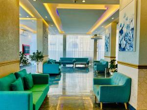 a lobby with blue couches and chairs in a building at Golden Dahlia Fintas in Kuwait