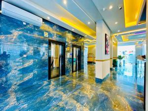 a lobby with a large blue marble wall at Golden Dahlia Fintas in Kuwait