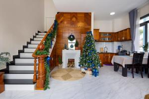 a living room with a christmas tree and a staircase at Nhà Giáng Sinh Trên Đồi Villa in Da Lat +25 photos