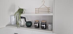 a shelf with jars and a plant on it at Apartman Bajka in Ruma