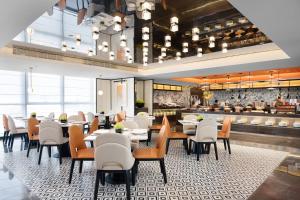 a dining room with tables and chairs and a restaurant at Hampton by Hilton Guangzhou Renhe Baiyun Airport-Free shuttle bus for canton fair in Guangzhou