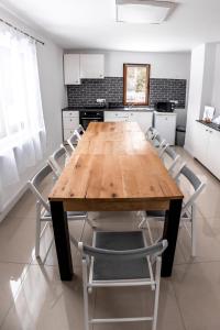 uma cozinha com uma mesa de madeira e cadeiras em Casa Tinca 1 em Izvoru Mureşului