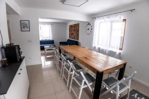 a kitchen and dining room with a wooden table and chairs at Casa Tinca 1 in Izvoru Mureşului