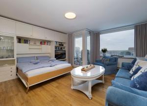 ein Schlafzimmer mit einem Bett, einem Sofa und einem Tisch in der Unterkunft Appartement Strandnah in Westerland