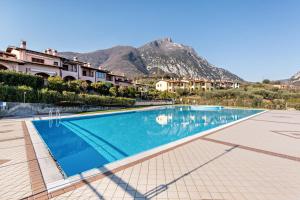 uma piscina num resort com montanhas ao fundo em Miralago 2 Beautiful view em Toscolano Maderno