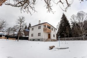 a white house with snow on the ground at Casa Tinca 1 in Izvoru Mureşului