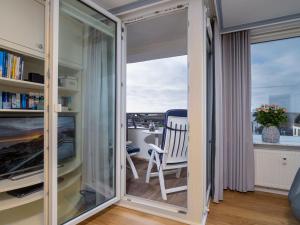 Zimmer mit einem Fenster, einem Stuhl und einem Schreibtisch. in der Unterkunft Appartement Strandnah in Westerland