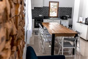 cocina con mesa de madera y sillas en Casa Tinca 1, en Izvoru Mureşului