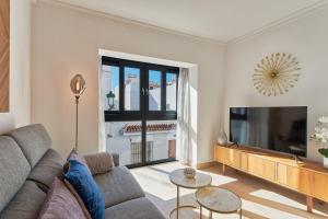 a living room with a couch and a flat screen tv at Solaga - Nueva 22 in Nerja