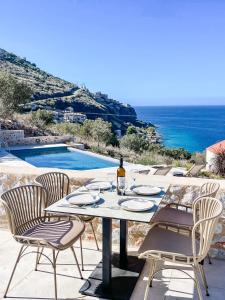 einen Tisch mit einer Flasche Wein und Stühlen auf einer Terrasse in der Unterkunft Eleonas Limeni in Limeni