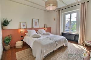 een slaapkamer met een groot bed en een raam bij Ti ma zud in Plestin-les-Grèves