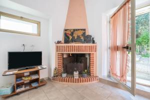 uma sala de estar com lareira e televisão em La Rocca del Pellegrino em Carbonia