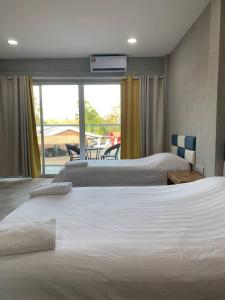 two beds in a hotel room with a balcony at 365 View Point Resort in Kaki Bukit