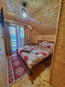 a bedroom with a bed in a wooden cabin at Cabana Dintre Munti in Vidra