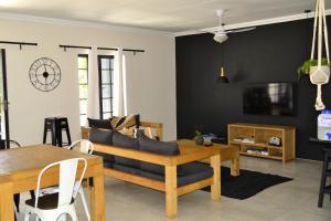 uma sala de estar com um sofá e uma mesa em Zebra Cottage - House - Backup Power - Fast WIFI em Pretoria