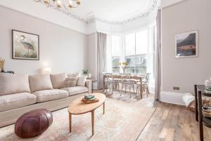 a living room with a couch and a table at Skye Sands - Alexandra Penthouse No 11 in St. Andrews