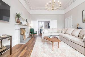 un soggiorno con divano bianco e camino di Skye Sands - 11 Alexandra Penthouse - St Andrews a St Andrews
