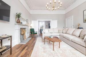 a living room with a white couch and a fireplace at Skye Sands - Alexandra Penthouse No 11 in St. Andrews