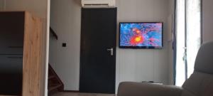 una camera con una porta nera e una TV a parete di Domaine Les Tamaris - Portes du Soleil - Villa 3 chambres avec Jardin - Climatisation - Accès Animations et Piscines inclus ! a Portiragnes