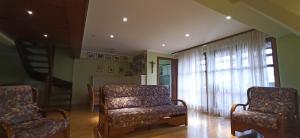 ein Wohnzimmer mit 2 Stühlen und einem Fenster in der Unterkunft Hotel Waldblick in Donaueschingen