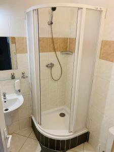 een badkamer met een douche en een wastafel bij Hotel Slovan in Žilina