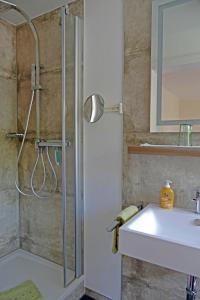 uma casa de banho com um chuveiro e um lavatório. em Gasthof zur Post em Schmallenberg
