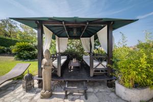einen Pavillon mit einem Tisch und einer Statue in der Unterkunft Villa Bellet in Nizza