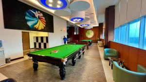 a billiard room with a pool table and chairs at Centaurus Apartment Mountain View Three Bed in Islamabad