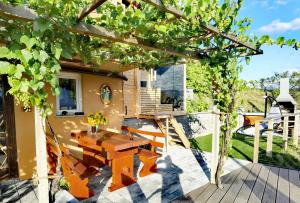 een patio met een tafel en stoelen en een huis bij Vineyard Cottage Sončni grič in Mirna