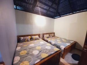 2 camas en una habitación con 2 camas sidx sidx sidx en Sri Sai Nature Stay en Madikeri