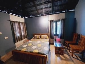 um quarto com uma cama, uma mesa e cadeiras em Sri Sai Nature Stay em Madikeri