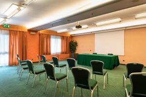 una sala de conferencias con mesa verde y sillas en Ripamonti Residence & Hotel Milano, en Pieve Emmanuele